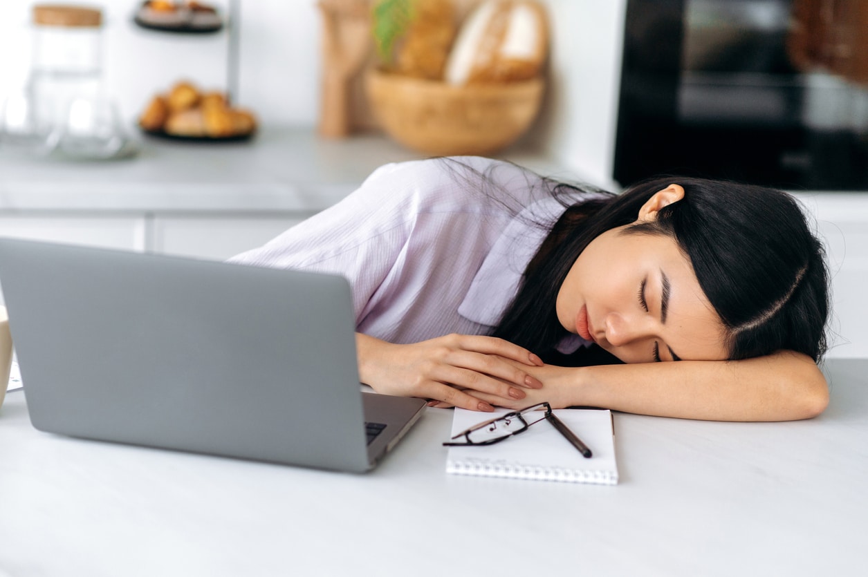 Why do I get sleepy when I study? Female student sleeping on desk in front of laptop.