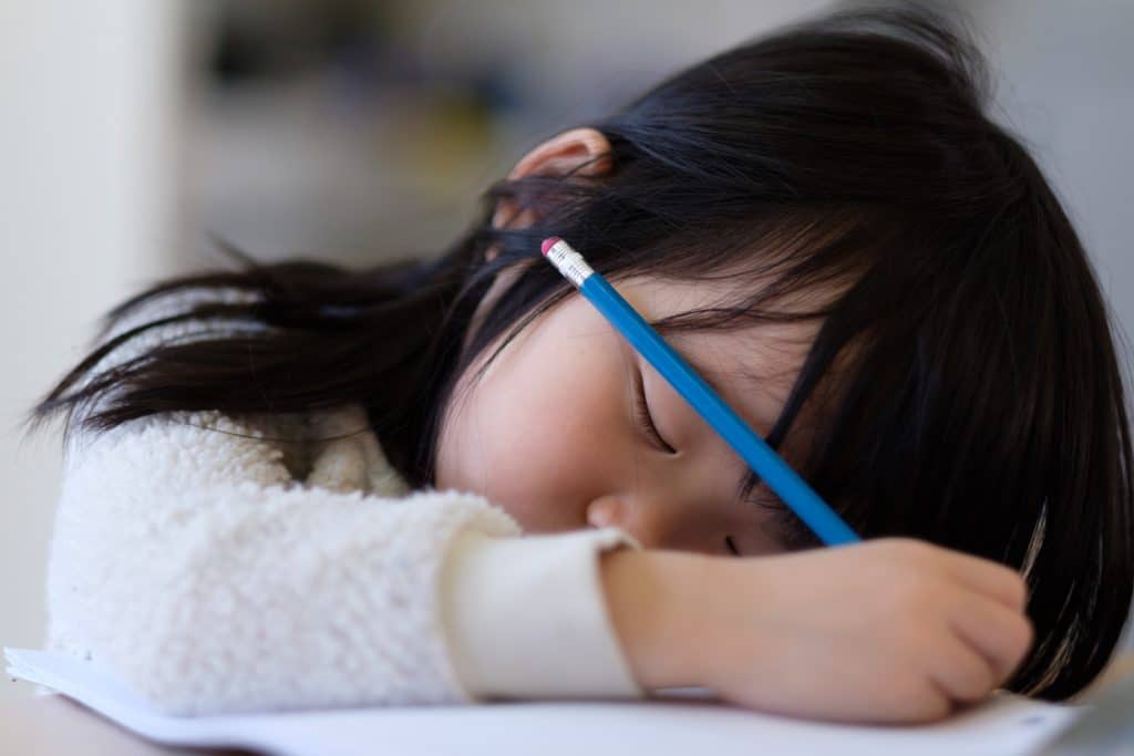 Why do I get sleepy when I draw? Asian young child fall asleep during drawing.