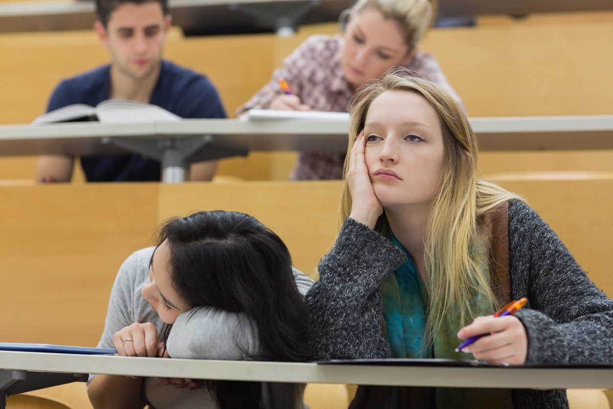 Why do I get sleepy during lectures? Girls falling asleep in lecture hall.