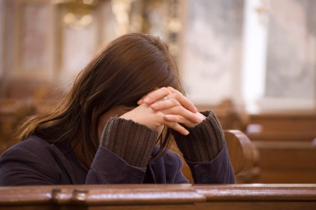 Why do I feel sleepy in church? Woman asleep in church.