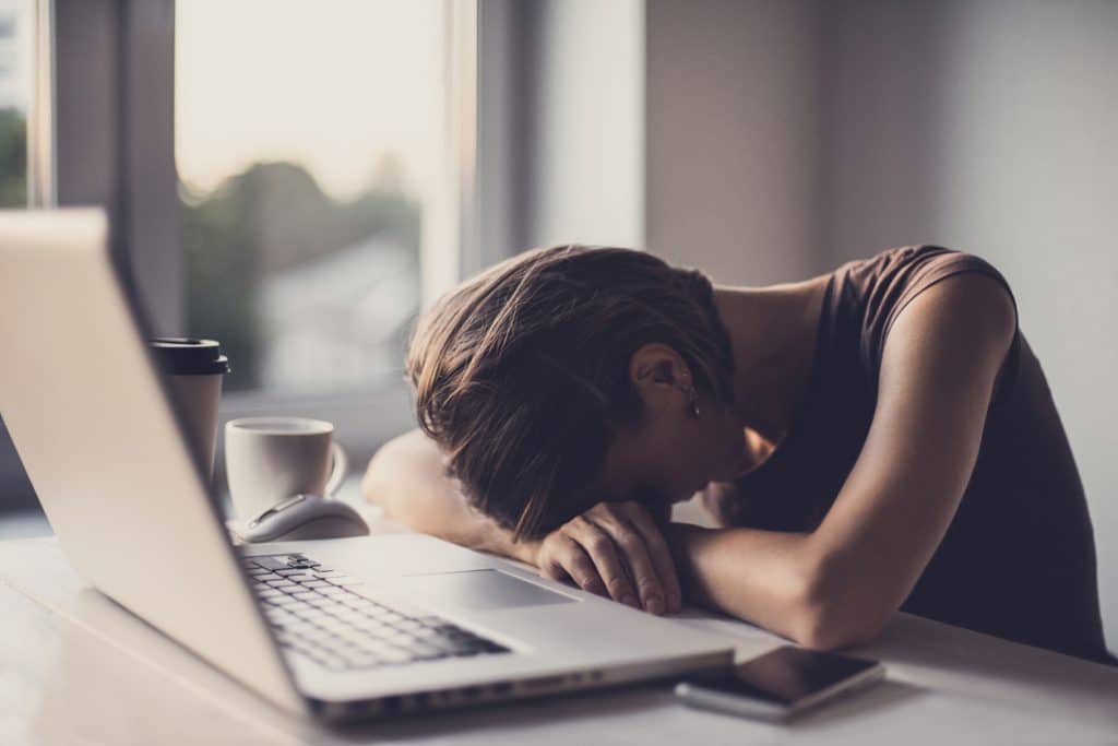 Why do I get sleepy when I'm on the computer? Tired woman asleep in front of computer.