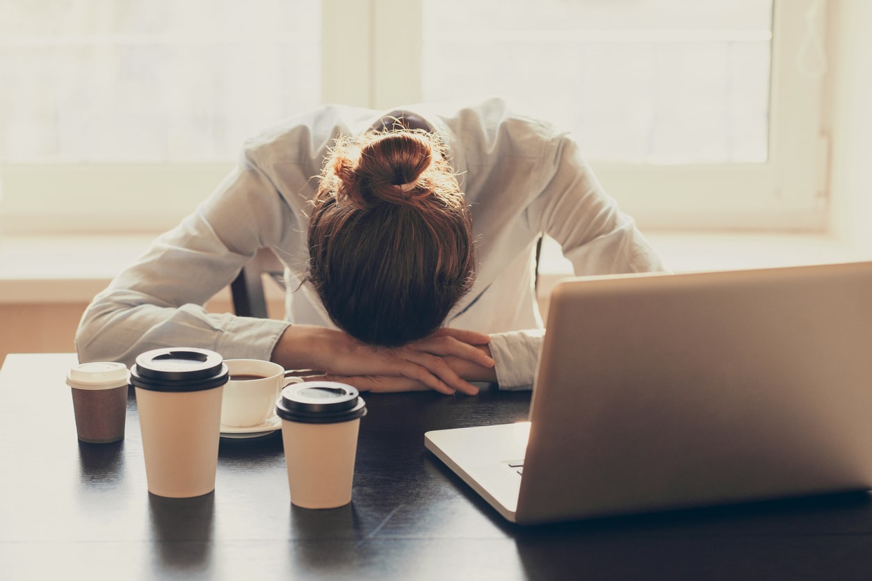 Why does my desk job make me so tired? Woman asleep at desk at work.